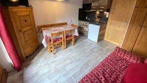 A compact room with a dining table, a small kitchenette, and a bed. - Cozy studio in Châtel, near center, with mountain corner, parking and balcony (Châtel)