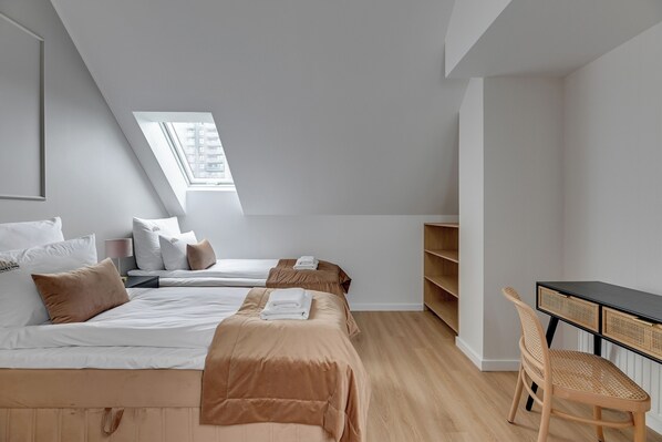 Un dormitorio moderno con dos camas, un escritorio y una silla.