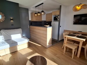 A compact living space with a kitchenette, a dining area, and a sofa. - Cozy apartment in Plagne 1800, 4-5 guests, pool access (La Plagne 1800)