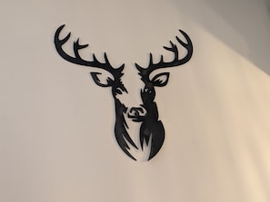Ein schwarzes Hirschgeweih-Logo an einer weißen Wand.