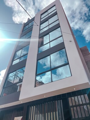 A modern building with multiple floors, large windows, and a clear sky. - Boa Mindelo City—a 3-minute walk from downtown and 10 minutes from the beach (Mindelo)