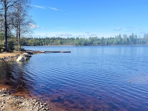 A calm lake with a dock and picnic table, surrounded by trees and clear skies. - 4 Star Holiday Home in Karlskrona (Eringsboda)