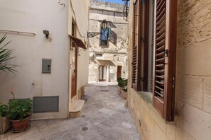 A narrow alleyway with stone flooring, potted plants, and traditional shutters on buildings. - 4217 Casa Lupiae by Barbarhouse (Lecce)