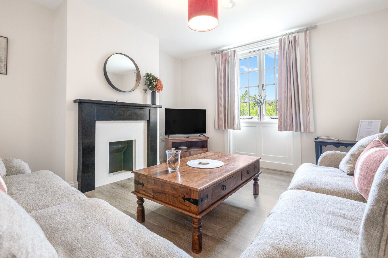 A living room with a fireplace, a television, a coffee table, and a sofa.