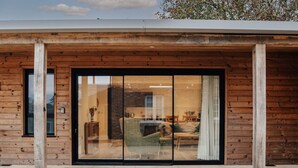 A modern building with a wooden facade and large glass sliding doors.