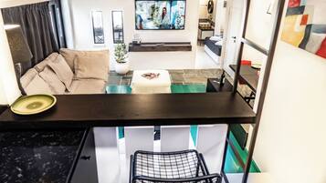 Uma sala de estar moderna com um sofá, uma mesa de centro e uma televisão.