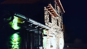 Un edificio con facciata in pietra e una torre con scala in legno.