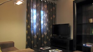 A modern living room with a flat-screen TV, a coffee table, a sofa, and a bookshelf. - Spacious Country House 'El Ventorro' with Mountain Views (Bretún)