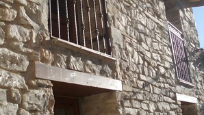 A stone building with barred windows and a wooden door. - Spacious Country House 'El Ventorro' with Mountain Views (Bretún)