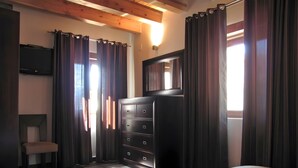 A bedroom with a bed, a dresser, a chair, a TV, and a window with curtains. - Spacious Country House 'El Ventorro' with Mountain Views (Bretún)