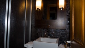 A bathroom with a rectangular sink, two wall-mounted lights, a mirror, and a towel rack. - Cosy Countryside Retreat 'Las Rozas' with Mountain Views (Bretún)