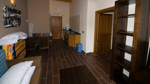 A room with a bed, a wooden ceiling, a kitchen area, and a door. - Cosy Countryside Retreat 'Las Rozas' with Mountain Views (Bretún)
