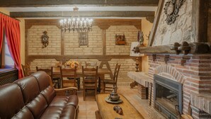Un salon doté d’une cheminée, de meubles en bois et d’un lustre.
