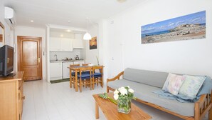 Een compact verblijf met een kitchenette, een eethoek en een bank met uitzicht op het strand.