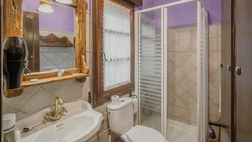 Un baño con lavamanos, inodoro y ducha.