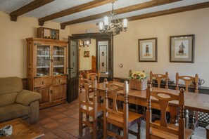 A dining area with wooden chairs, a table, and a cabinet with glass doors.