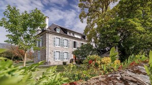 A stone building with multiple windows and a garden in the foreground. - Pyrénées Cottage with Mountain View, Private Terrace, and Wi-Fi – Top-Rated Accommodation (Lau-Balagnas)
