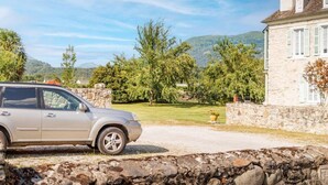 A stone building with a paved driveway and a parked car. - Pyrénées Cottage with Mountain View, Private Terrace, and Wi-Fi – Top-Rated Accommodation (Lau-Balagnas)