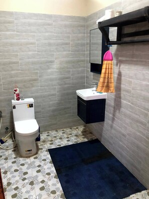 A small bathroom with a toilet, sink, and a towel rack with a towel. - Mountain View House Kampot (Kampot)