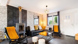 Una sala moderna con chimenea, sofá de cuero negro y una mesa de centro de cristal.
