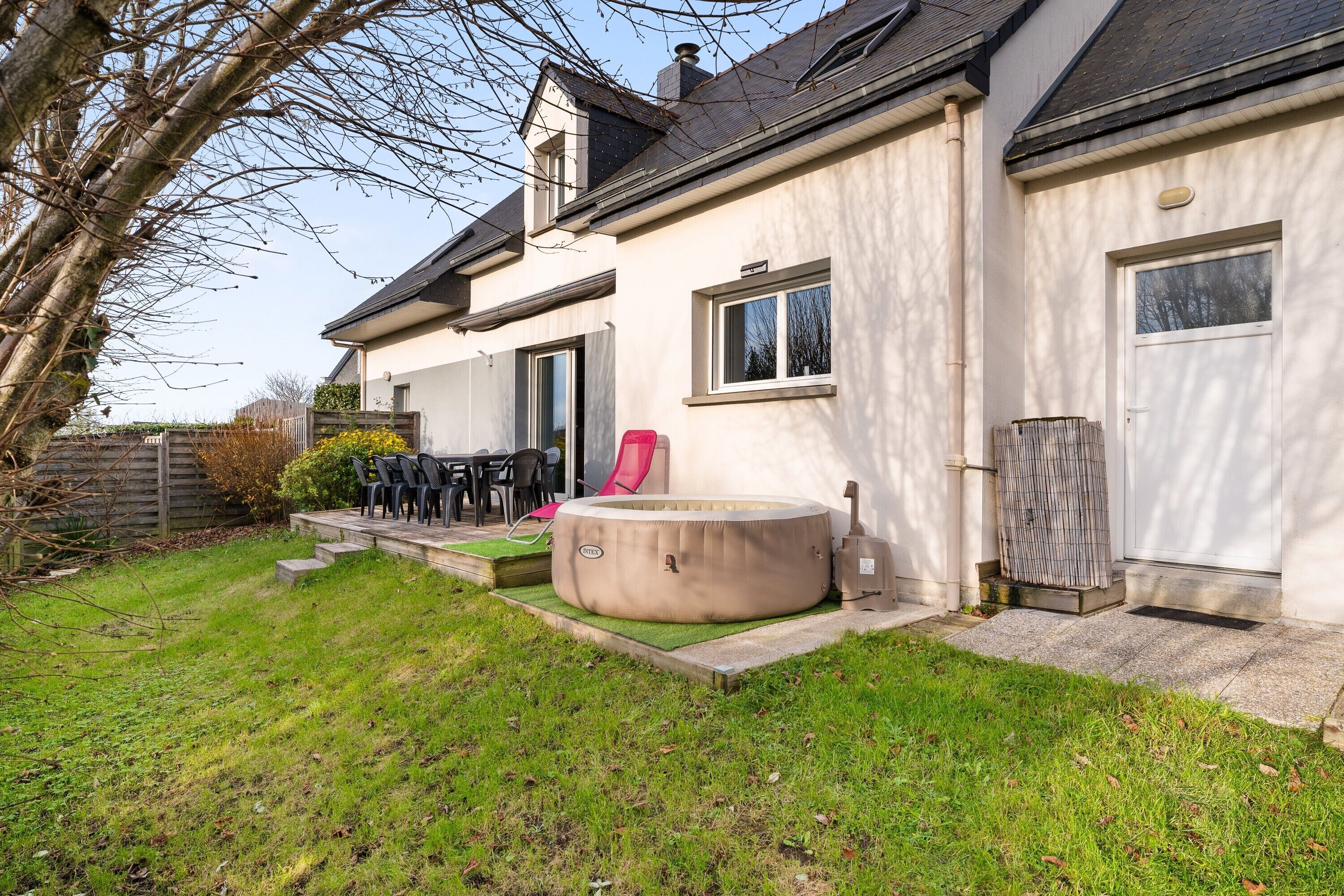 A house with a hot tub, outdoor seating, and a garage.