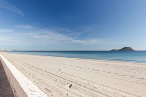 A beach with a clear sky, a sandy shore, and a distant island. - Apartment 'Isla Grosa' with Sea Views, Wi-Fi and Air Conditioning (La Manga del Mar Menor)