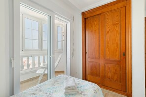 A room with a bed, a wooden door, and a balcony with a white railing. - Apartment 'Isla Grosa' with Sea Views, Wi-Fi and Air Conditioning (La Manga del Mar Menor)