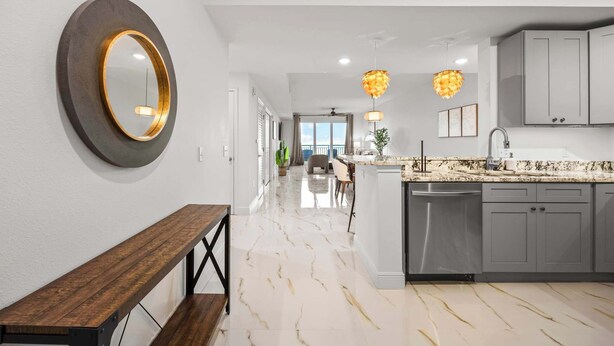 A modern kitchen with a marble floor, grey cabinets, and pendant lighting. - RIVER FLY IN: The Merritt, Launchpad Lookout View (Merritt Island)
