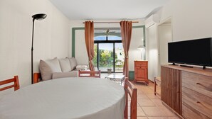Een hotelkamer met een bed, een televisie, een eettafel, een bank en uitzicht op de omgeving.