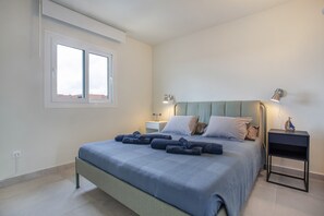 Une chambre à coucher avec un lit, des tables de chevet et une fenêtre.