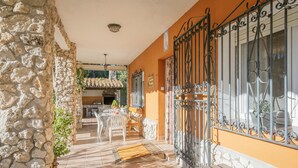 A stone wall, a wooden bench, a metal gate, and a tiled floor. - Country House 'Ribera Del Duero' with Mountain View, Private Pool and Private Garden (TRASPINEDO)