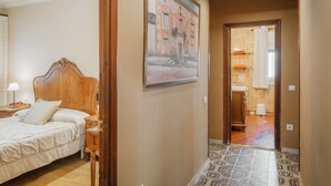 A hotel room with a bed, a nightstand, a painting on the wall, and a bathroom visible through an open door. - Country House 'Ribera Del Duero' with Mountain View, Private Pool and Private Garden (TRASPINEDO)