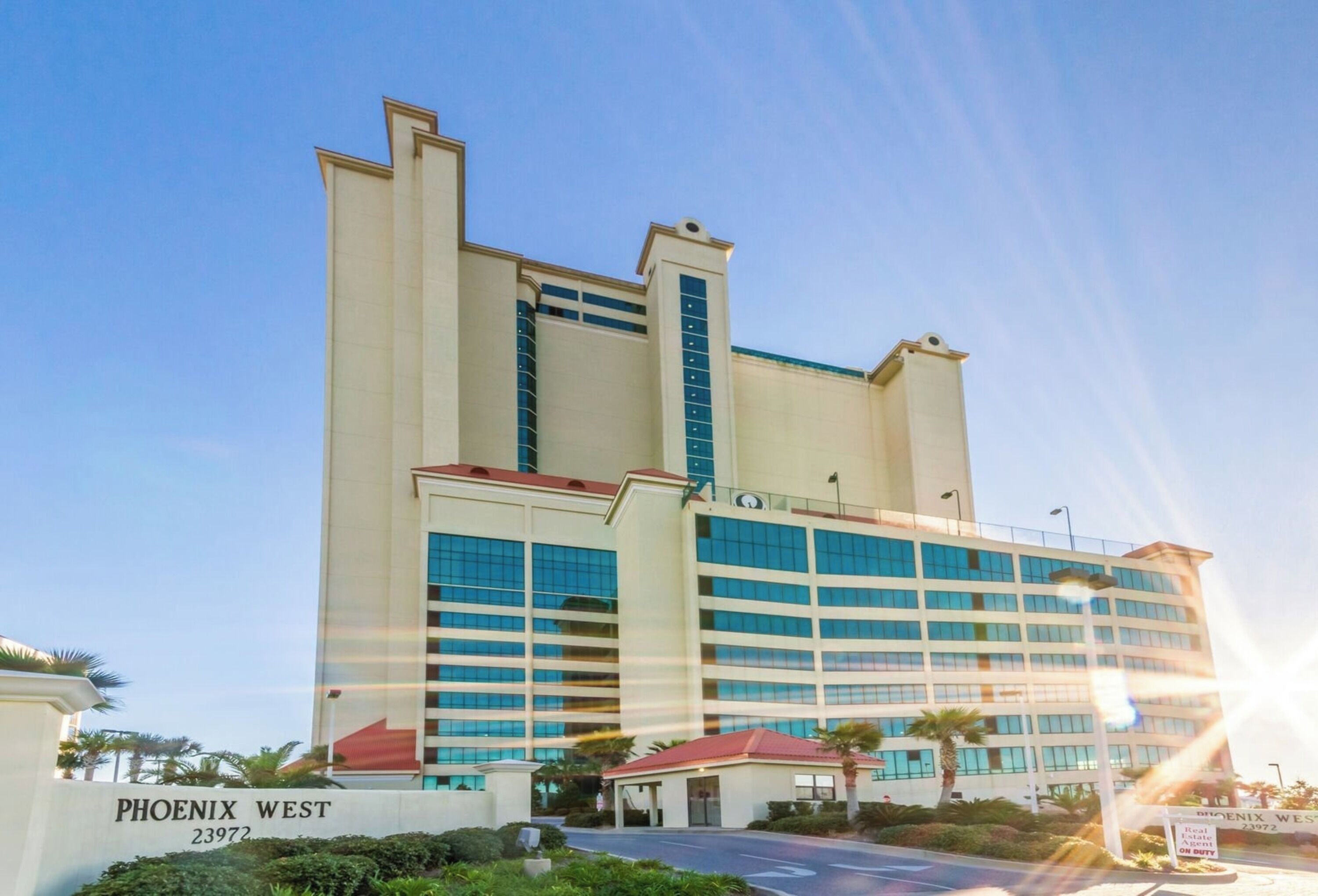 A multi-story hotel with a prominent entrance and a sign reading "PHOENIX WEST 23972".