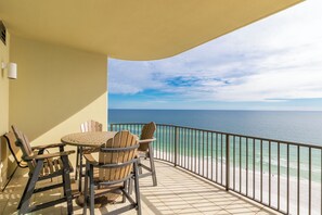 A balcony with a table and chairs, overlooking a beach and the ocean. - Phoenix West 1506 (Orange Beach)