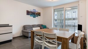 Een moderne keuken met een eettafel, stoelen, een bank en een wandkunstwerk.