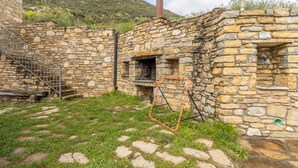 Un edificio de piedra con una escalera, una ventana y un portón de metal.
