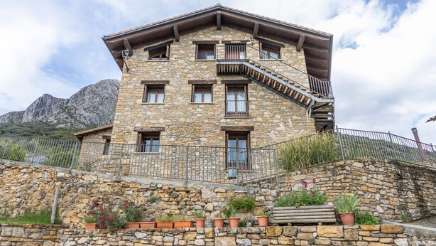 Un edificio de piedra con varias ventanas, un balcón y una escalera que conduce al piso superior.