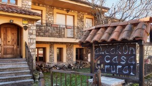 A stone building with a wooden door, a balcony, and a sign that reads 'Casa Rural.' - Country House 'Aldaron' with Mountain View, Private Garden and Wi-Fi (BOCA DE HUERGANO)