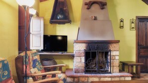 A cozy living room with a fireplace, wooden furniture, and a flat-screen TV. - Country House 'Aldaron' with Mountain View, Private Garden and Wi-Fi (BOCA DE HUERGANO)