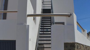 A white building with a metal staircase leading to a door. - Country House 'Daniela 2' with Sea View, Wi-Fi and Air Conditioning (El Pozo de los Frailes)