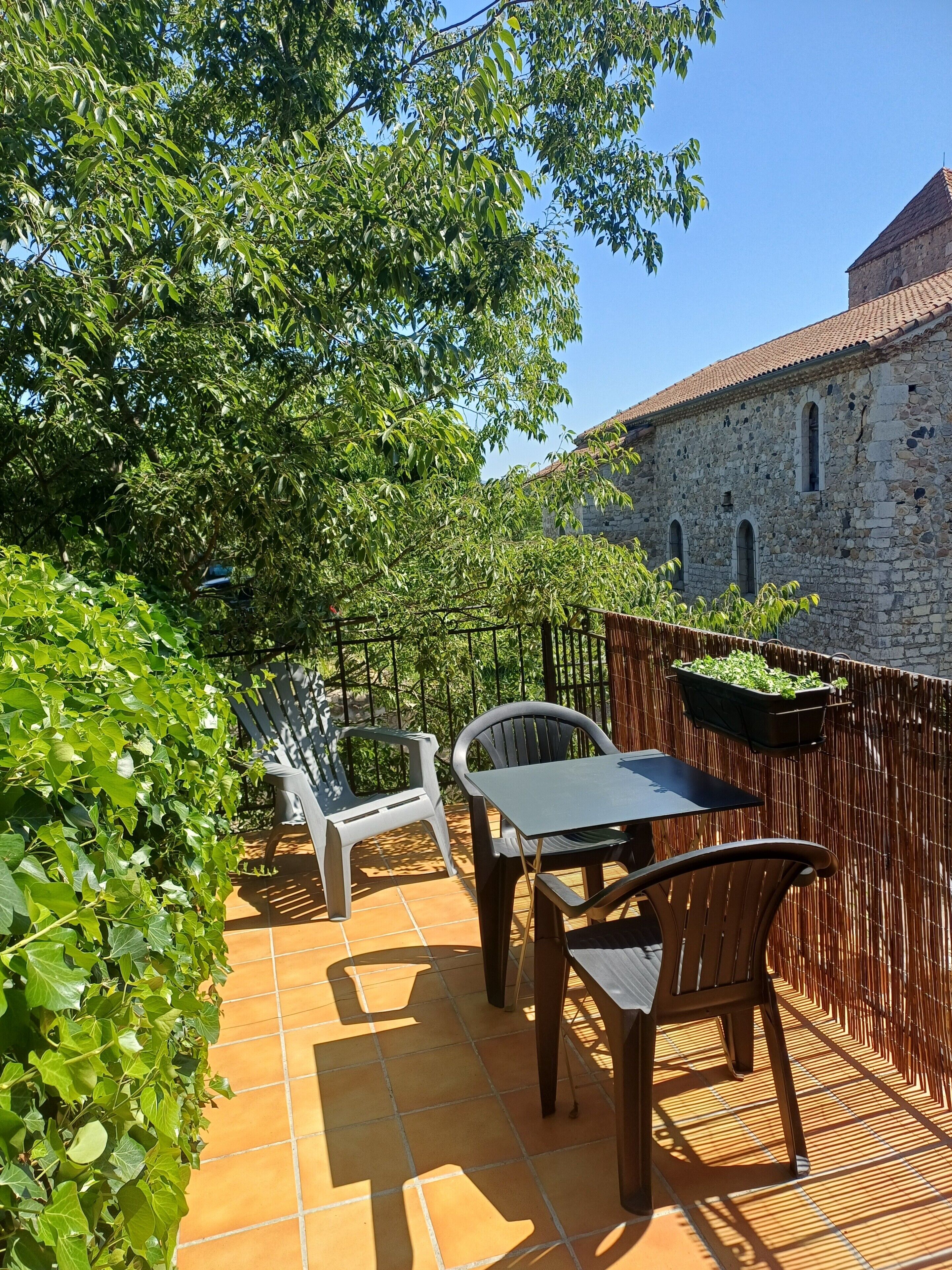 Eine Terrasse im Freien mit einer Steinmauer, einem Tisch und zwei Stühlen.