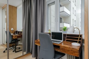 A modern office space with a wooden desk, a laptop, a chair, and a lamp. - Lumina apartment in center Warsaw (Warsaw)