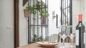 Une table avec une bouteille de vin, deux verres et une assiette décorative.