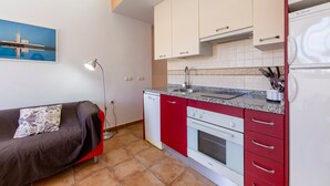 A compact kitchen with a dishwasher, oven, and a microwave.
