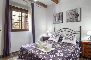 A bedroom with a bed, two nightstands, a window with curtains, and artwork on the wall. - El Cortijo 2 Apartment: pool, terrace & AC in Conil de la Frontera (Conil de la Frontera)