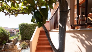 A staircase leading up to a building with a stone retaining wall and a tree. - Mishti Blu Studio al Mare by Wonderful Italy (Olbia)