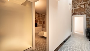 A hallway with a modern design, featuring a patterned floor and a stone wall. - Casa di Design tra le Mura by Wonderful Italy (Palermo)