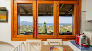 Ein Zimmer mit einem raumhohen Holzrahmenfenster mit Blick auf eine malerische Landschaft.