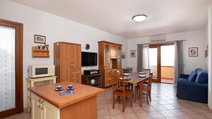 A compact living space with a kitchenette, dining area, and a sofa.