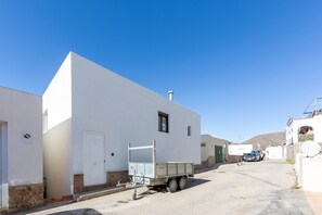A white building with a flat roof, a small window, and a door.